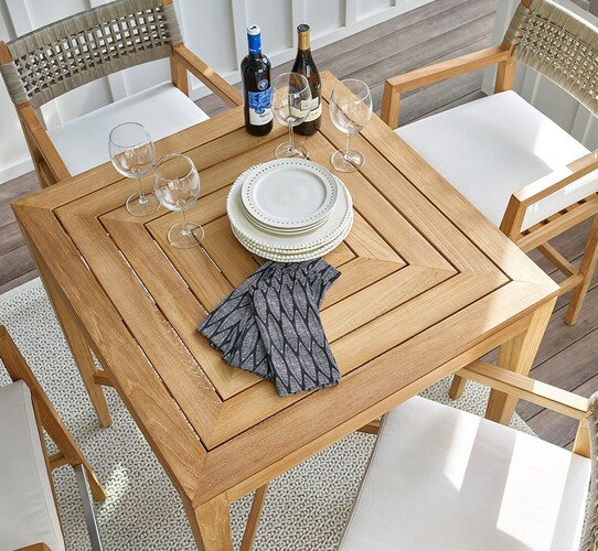 Square bar table with plates and wine glasses on top