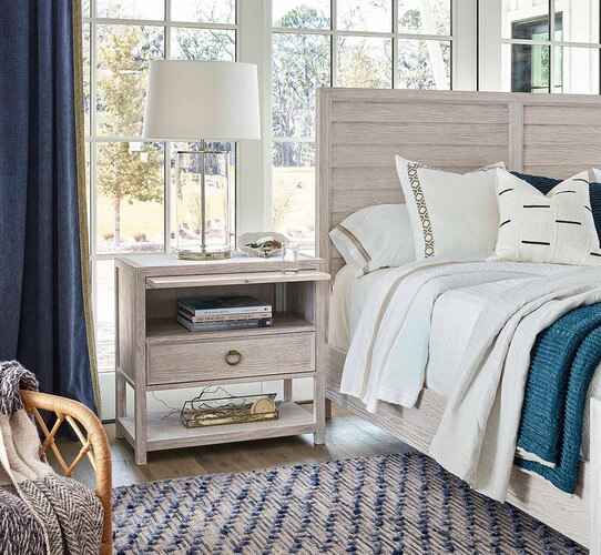 White wood bed next to a wooden nightstand