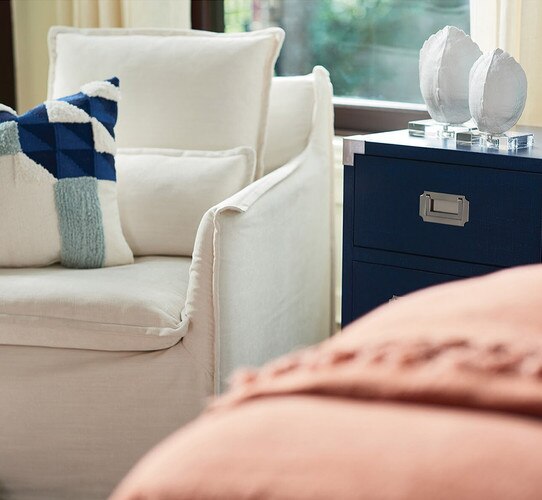White swivel chair next to a blue chest