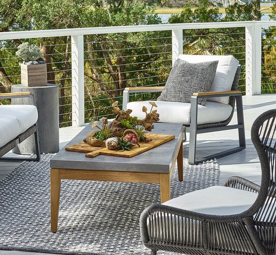 Porch with concrete coffee table beside two accent chairs