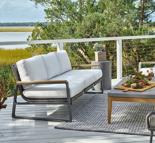 White and wood sofa on a patio overlooking a marsh