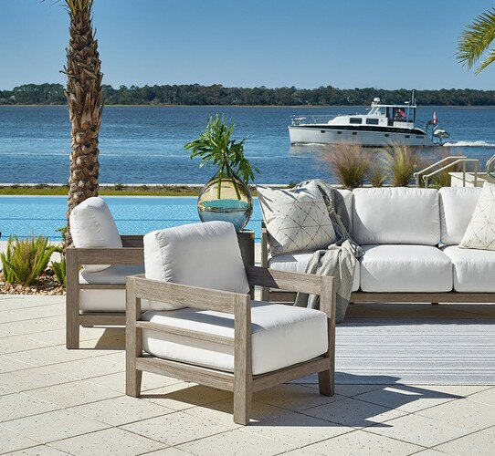 Lounge chair beside a pool in front of a lake