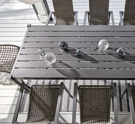 Black metal outdoor table with decorative glass bulbs on top.
