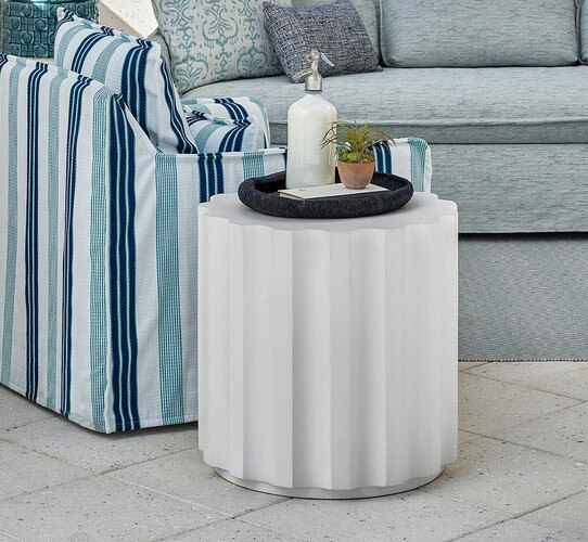White concrete side table beside a slip cover chair