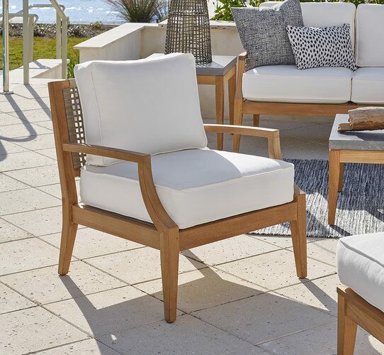 Wood chair with white cushions on a patio