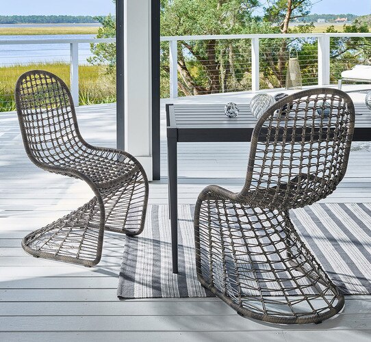 Two woven chairs beside a metal table on a patio