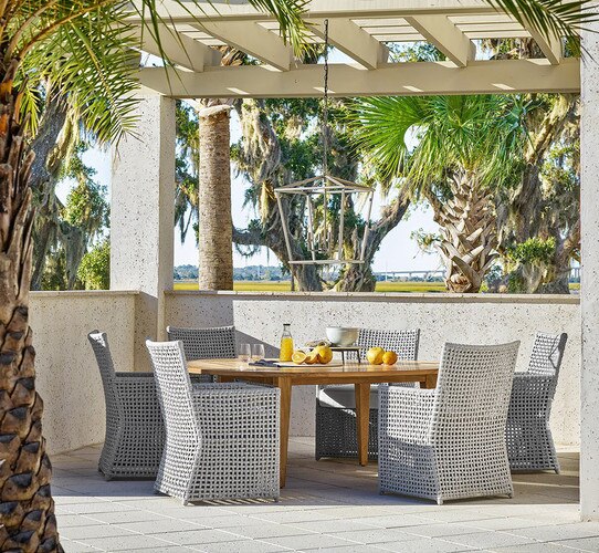 Patio gazebo with a wood dining table and six woven chairs