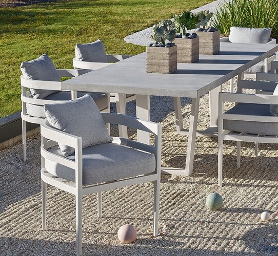 Long metal and concrete table on a patio with chairs