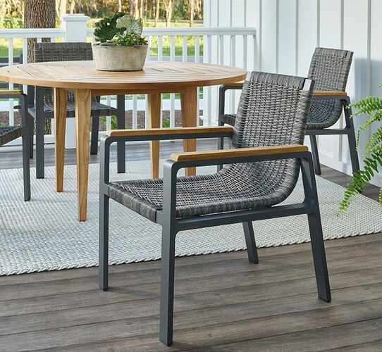 Woven chair with wood arms on a patio