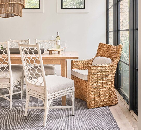 Woven white chairs around a wood dining table
