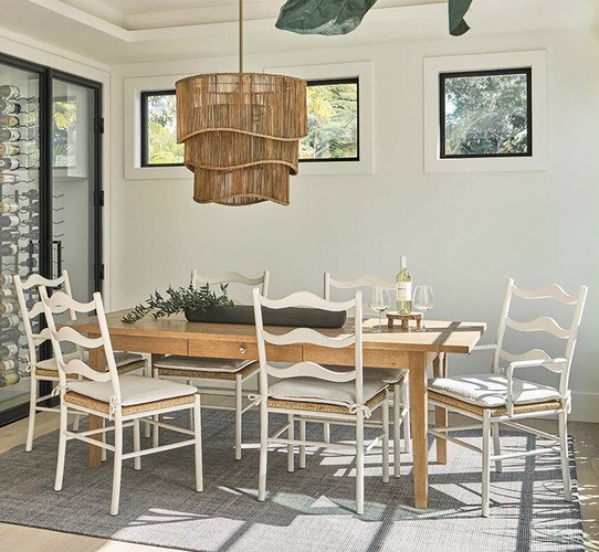 Dining room with wine fridge and wooden table with white chairs