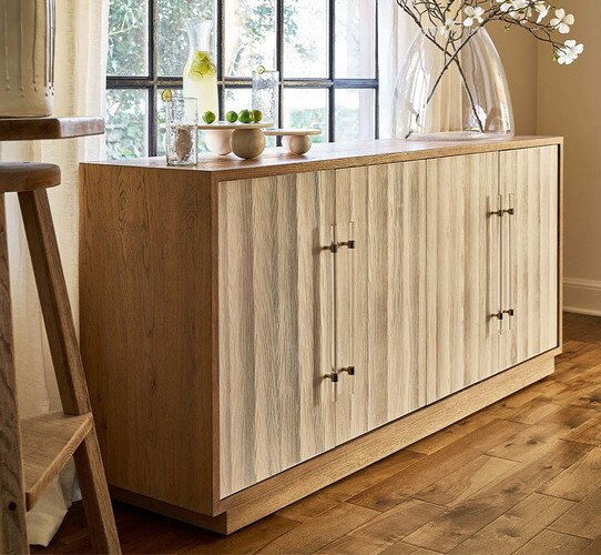 Wood credenza holding a large vase and marble plates of limes