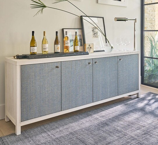 Wood credenza with a row of wine bottles and picture frames