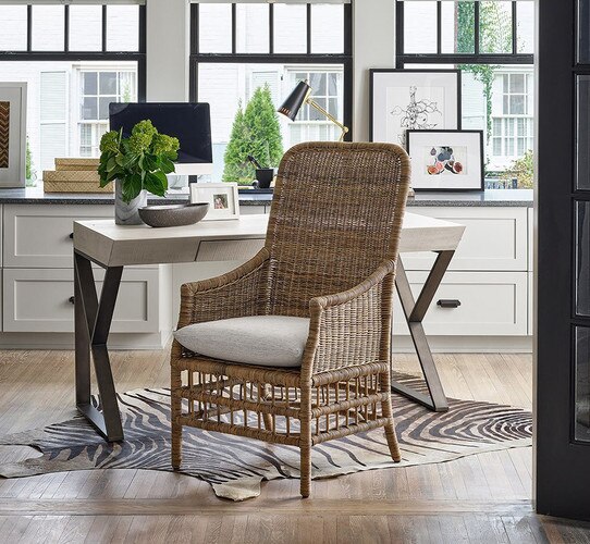 Wicker chair in front of a desk.