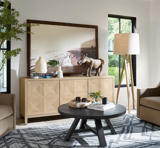 Living room with a wood crezena holding a large horizontal painting of a beach