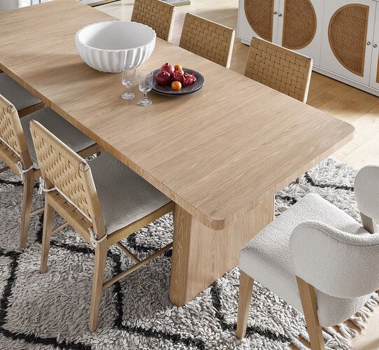 Wood dining table and chairs on a white and black rug