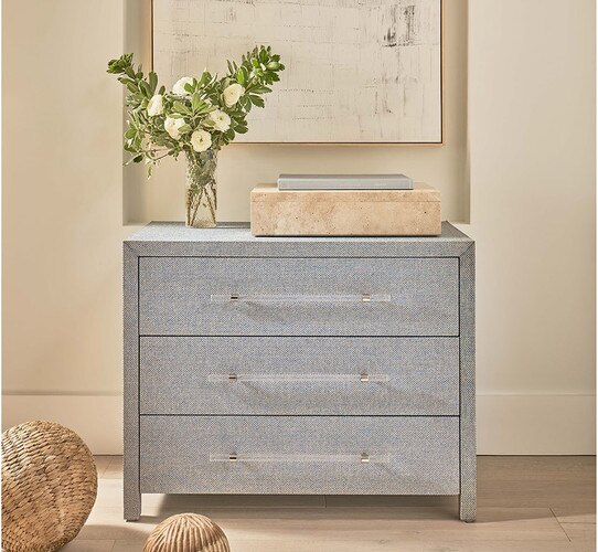 Textured dresser holding a stone box and vase of flowers