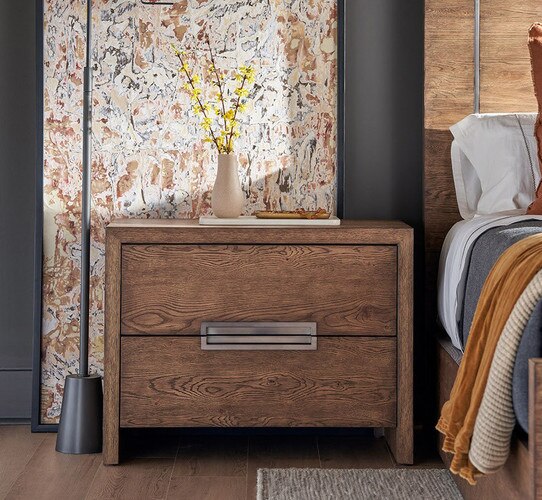 Wood nighstand with metal inlaid handles holding a tray with a vase