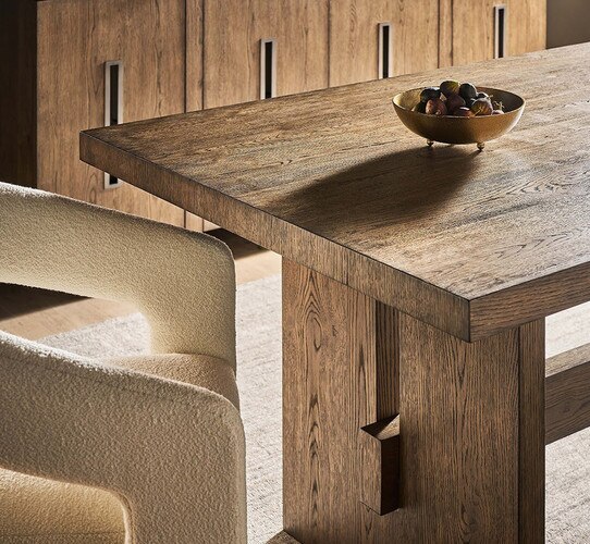 Wood dining table holding metal bowl of nuts