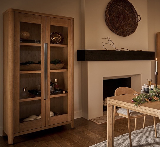 Display cabinet with decor beside a large fireplace