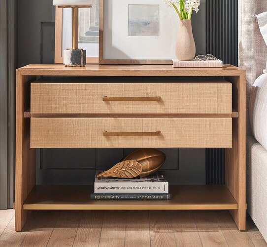 Wood nightstand with open lower shelf holding dÃ©cor and books