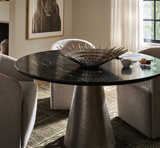 Circular black marble dining table metal decorative bowl in the center
