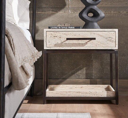 Metal and wood nightstand holding a black book and black sculptural object
