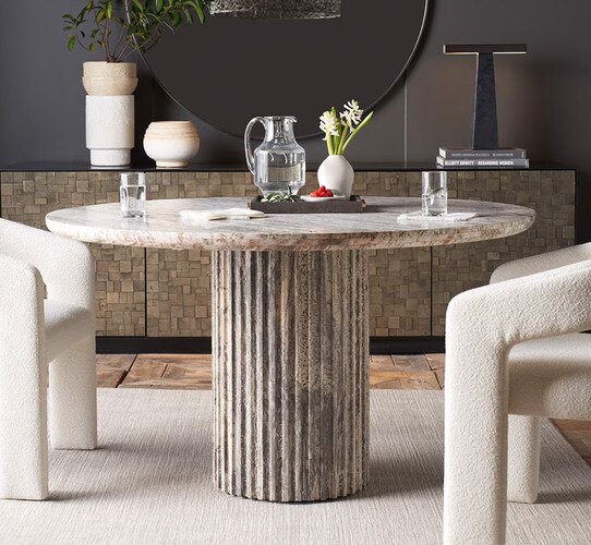 Circular dining table surrounded by white chairs