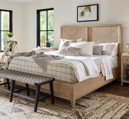 Wood panel bed with two wood nightstands beside it