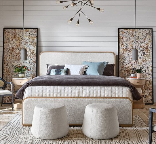 Linen and wood bed frame with two large vertical abstract paintings beside it