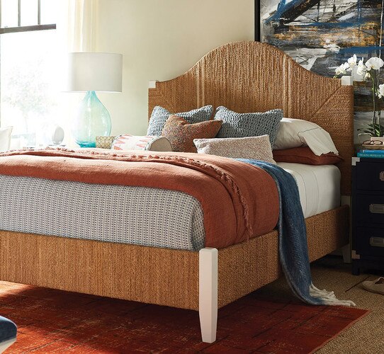 White and wicker bed stand with blue nightstands beside it