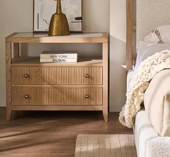 Wood nighstand beside a white bed