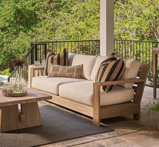 Outdoor teak sofa on a stone porch