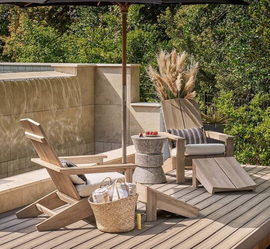 Two wood adirondack chairs with umbrellas between them