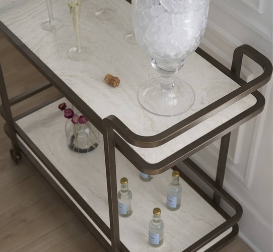 Gold bar cart holding glasses and champagne