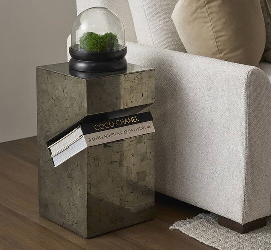 Metal side table with indent to hold boks beside a sofa