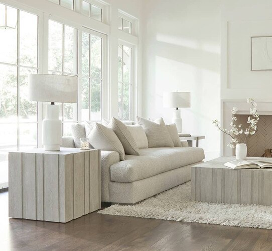 White wood side table beside a beige sofa