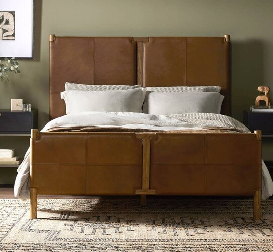 Leather and brass bed frame with white sheets and pillows