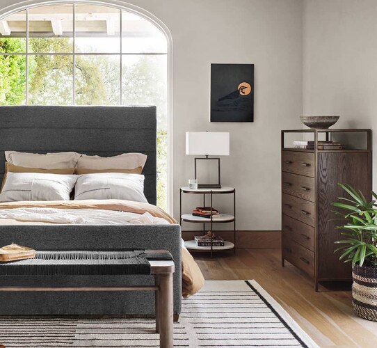 Bedroom with tall window bed frame and wood dresser