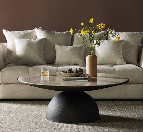 Circular marble coffee table in front of a white sofa