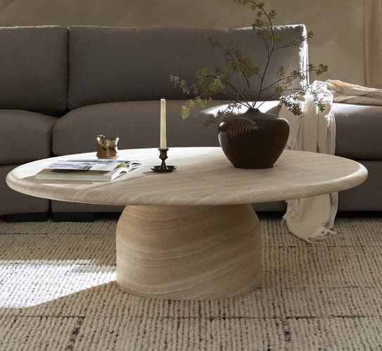White marble circular coffee table in front of a gray sofa