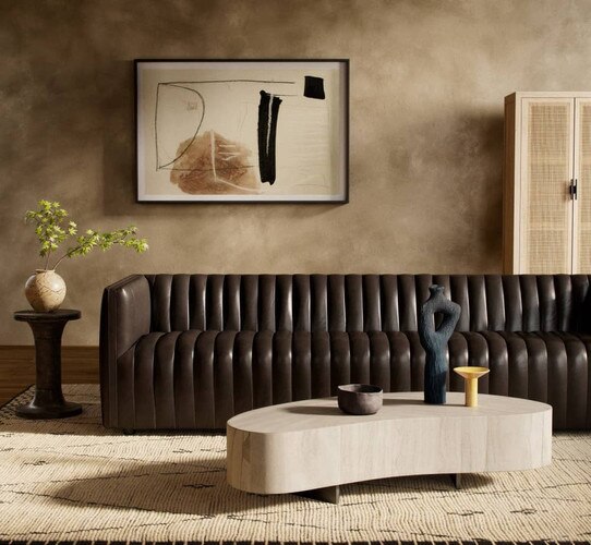 Leather sofa with an organic shaped coffee table in front of it