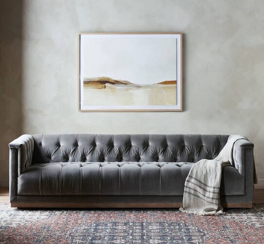 Gray sofa under a landscape painting