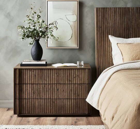Modern wood nightstand with a black vase on top of it