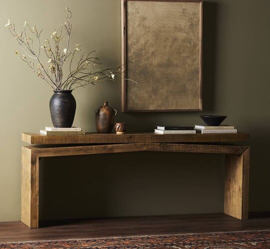 Wood console tables with a vase holding sticks and foliage