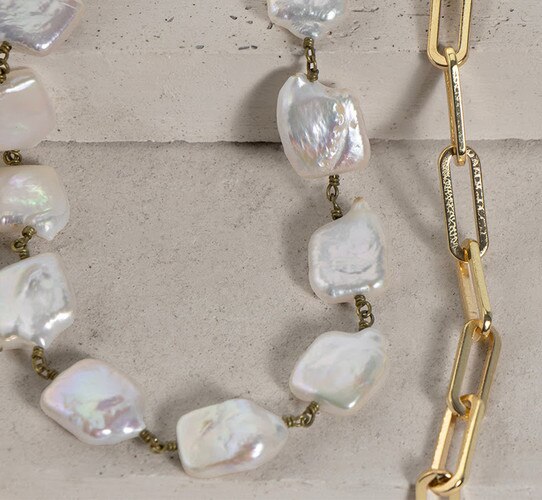 Pearl and gold necklace with a chain to the right