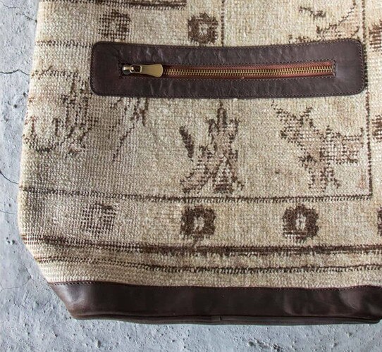 Leather and canvas bag with zipper.