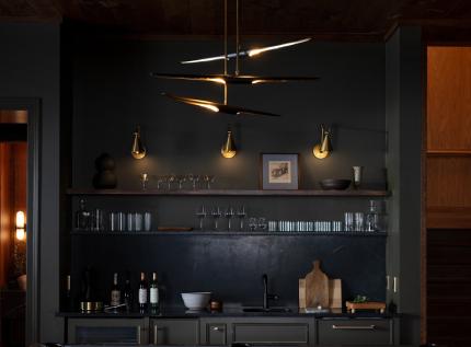 dark bar room with three lit sconces and shelves