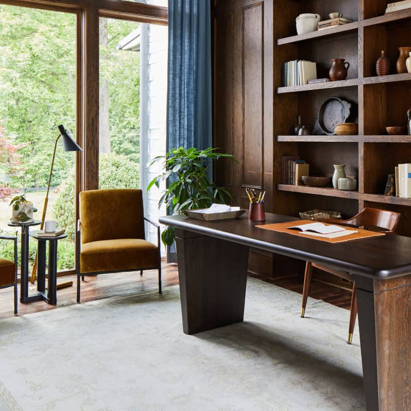 office desk next to floor lamp and white pendant light