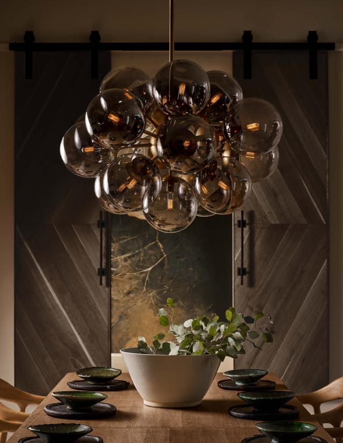 natural brass chandelier above circular table with flowers on top